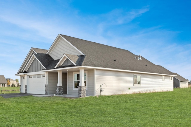 rear view of property with a garage and a lawn