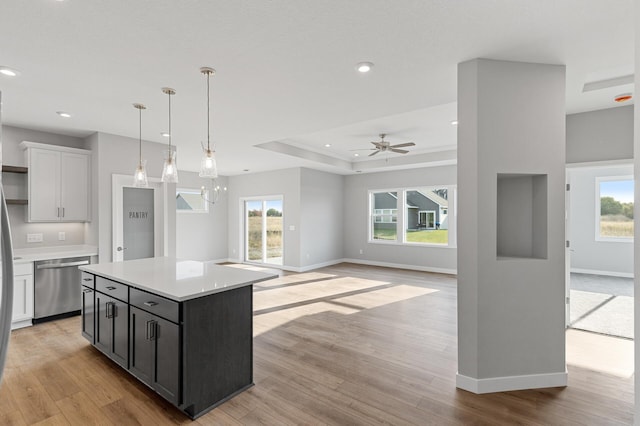 kitchen featuring dishwasher, white cabinets, a center island, and plenty of natural light