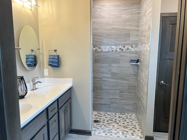 bathroom featuring tile patterned floors, tiled shower, and vanity