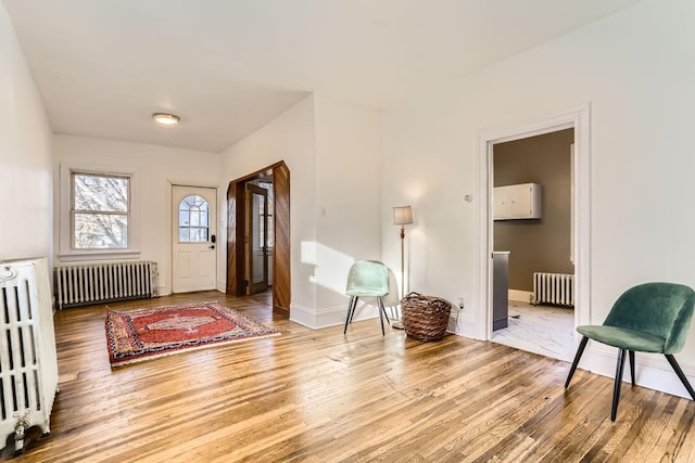 foyer with radiator heating unit and wood-type flooring