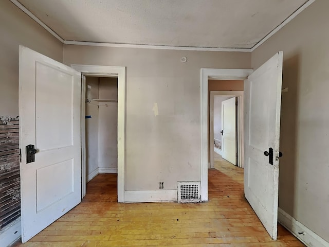 bedroom featuring ornamental molding, a closet, and light hardwood / wood-style floors