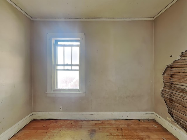 unfurnished room with light wood-type flooring and crown molding