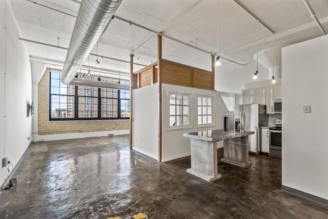 kitchen with stainless steel appliances, a kitchen island, decorative light fixtures, a kitchen bar, and white cabinets