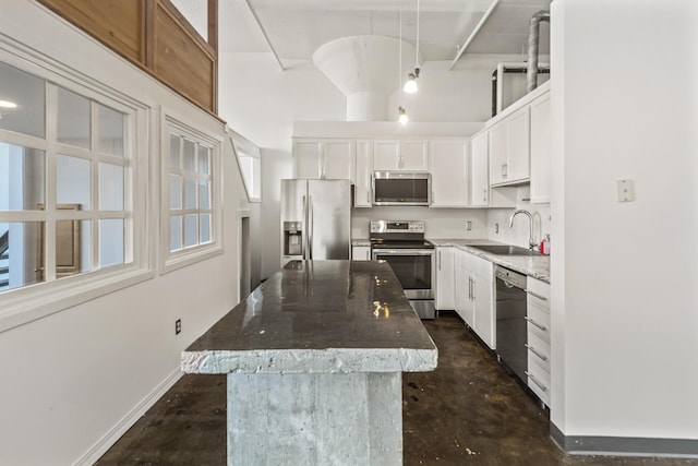 kitchen with white cabinetry, sink, a center island, pendant lighting, and appliances with stainless steel finishes