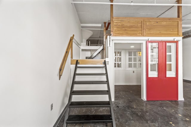 staircase featuring concrete floors