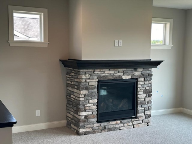 interior details with carpet flooring and a stone fireplace