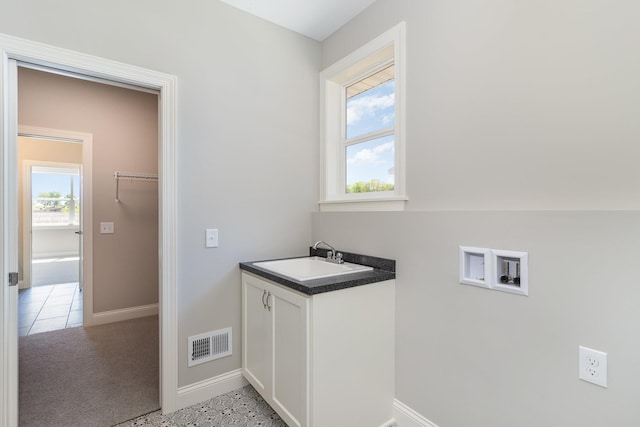 clothes washing area with cabinets, hookup for a washing machine, a wealth of natural light, and sink