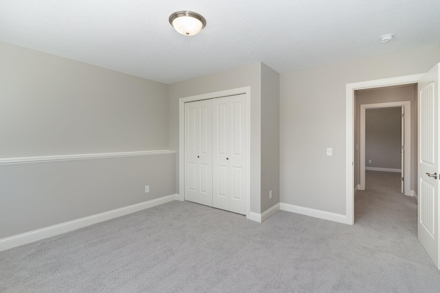 unfurnished bedroom featuring light colored carpet and a closet