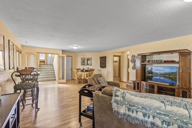 living room featuring light hardwood / wood-style floors and a textured ceiling