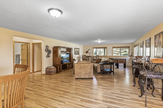 living room with billiards, light hardwood / wood-style flooring, and a textured ceiling