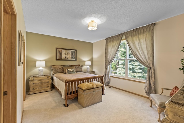 bedroom featuring light colored carpet and a textured ceiling