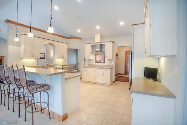 kitchen with a kitchen breakfast bar, sink, wall chimney range hood, light tile patterned floors, and hanging light fixtures