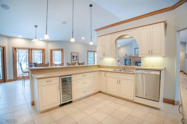 kitchen featuring cream cabinets, hanging light fixtures, sink, wine cooler, and stainless steel dishwasher