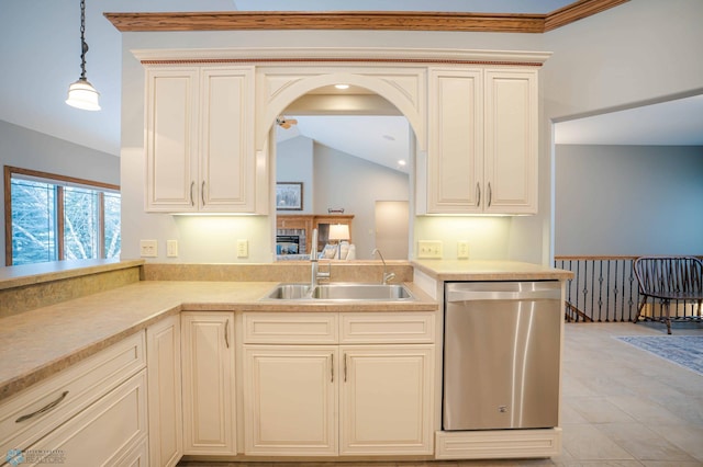 kitchen with stainless steel dishwasher, sink, cream cabinets, decorative light fixtures, and lofted ceiling