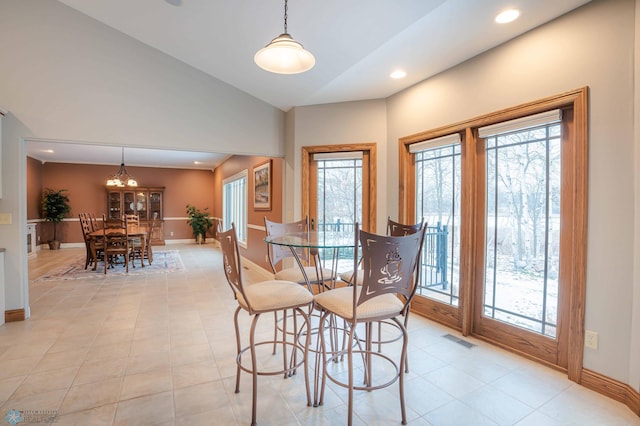 dining space with a chandelier and vaulted ceiling