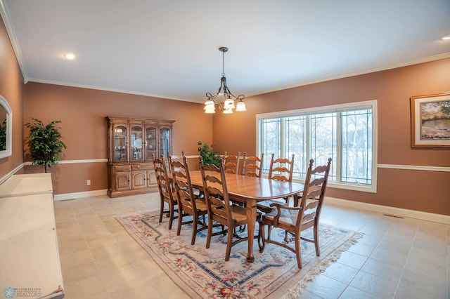 tiled dining area featuring crown molding and an inviting chandelier