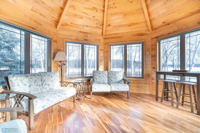 living area with light hardwood / wood-style flooring, beamed ceiling, wooden ceiling, and high vaulted ceiling