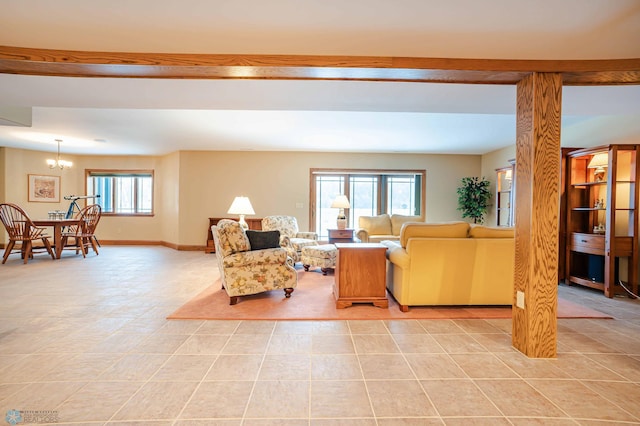 living room featuring decorative columns, light tile patterned floors, and an inviting chandelier