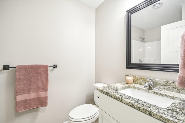 bathroom featuring a shower, vanity, and toilet