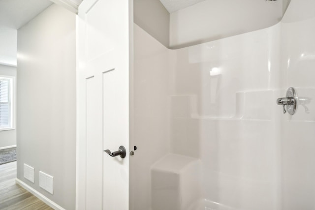 bathroom featuring a shower and hardwood / wood-style floors