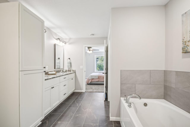 bathroom featuring ceiling fan, a washtub, and vanity