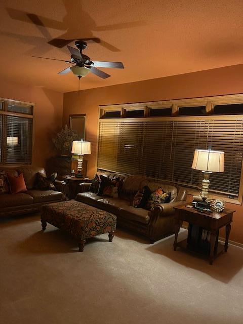 carpeted living room featuring ceiling fan