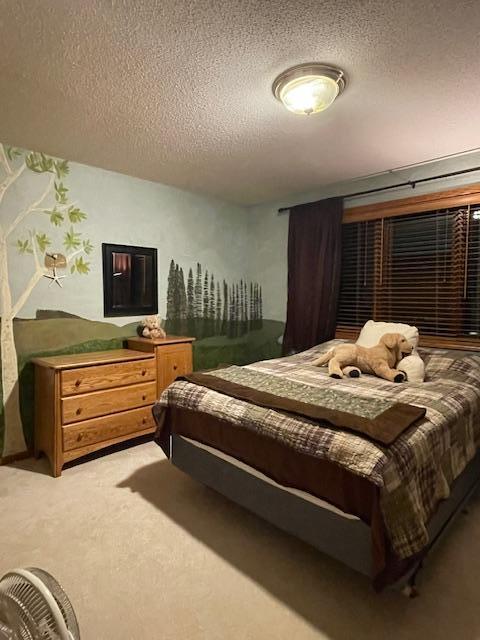 bedroom featuring a textured ceiling and light carpet