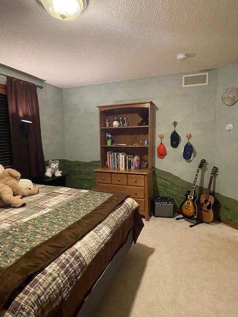 carpeted bedroom featuring a textured ceiling