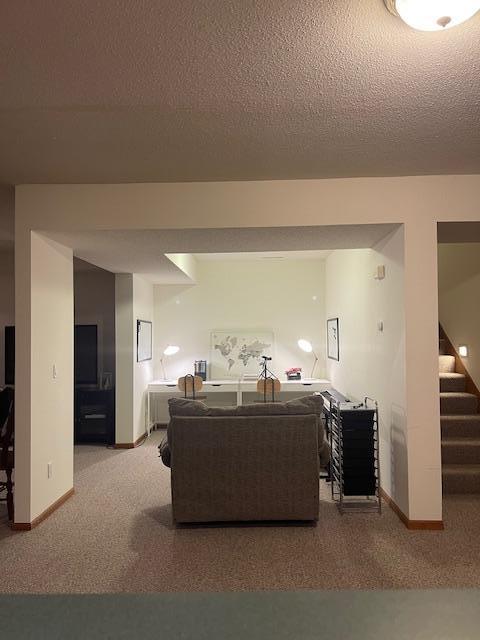 living room with a textured ceiling and light carpet