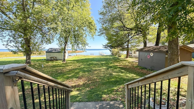 view of yard featuring a water view and a storage shed