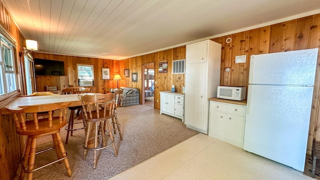 dining space featuring wooden walls and wooden ceiling