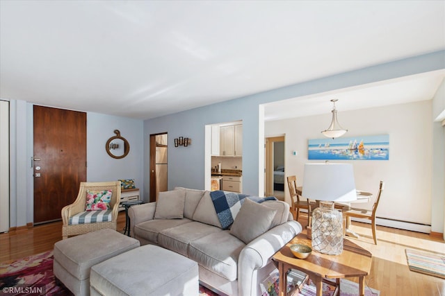 living room featuring a baseboard heating unit and light wood-type flooring