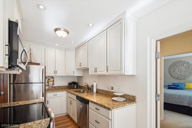 kitchen with white cabinetry, stainless steel appliances, and stone countertops