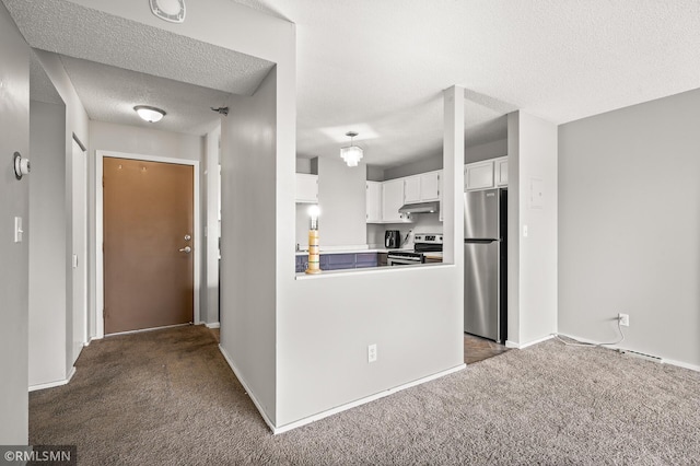 kitchen with dark colored carpet, kitchen peninsula, stainless steel appliances, white cabinetry, and a textured ceiling