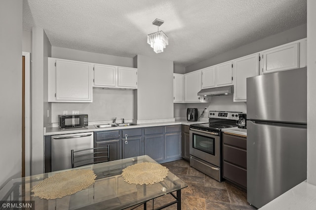 kitchen featuring a textured ceiling, white cabinetry, hanging light fixtures, and stainless steel appliances