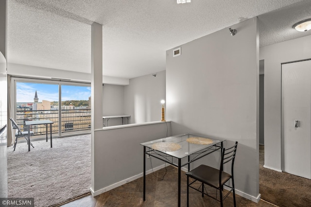 dining space featuring a textured ceiling and carpet flooring