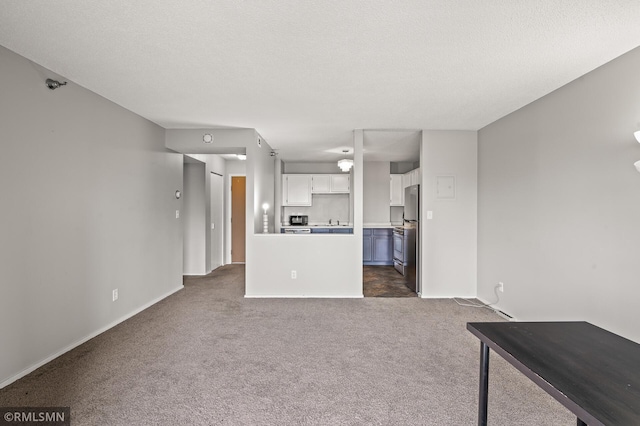 unfurnished living room with a textured ceiling and dark carpet