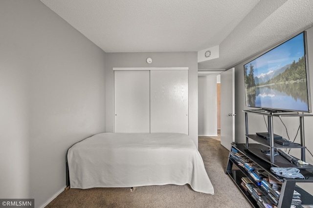 bedroom with carpet, a textured ceiling, and a closet