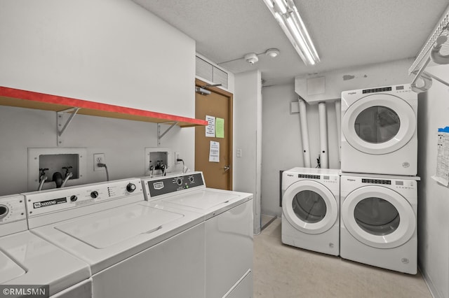 clothes washing area featuring independent washer and dryer, a textured ceiling, and stacked washing maching and dryer