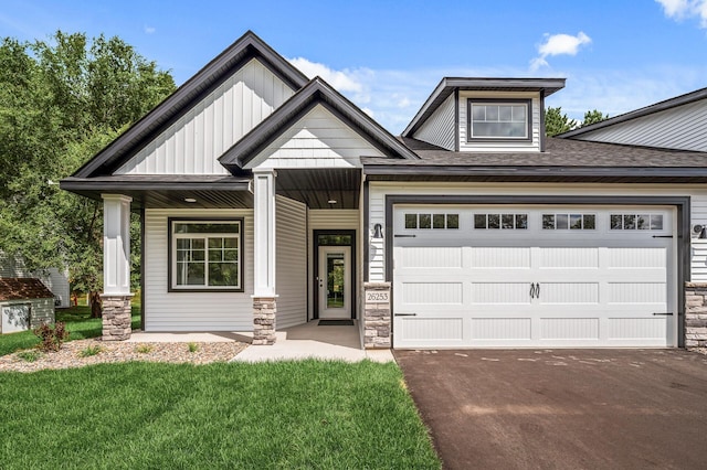 craftsman-style home featuring a front yard, a garage, and a porch