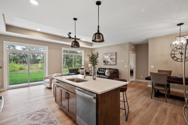 kitchen with dishwasher, a wealth of natural light, sink, and an island with sink