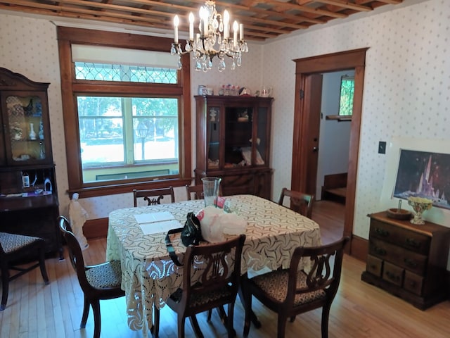 dining room featuring an inviting chandelier, wallpapered walls, and light wood-style flooring
