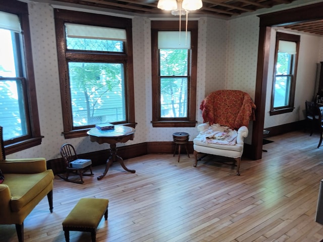 sitting room featuring a ceiling fan, wallpapered walls, and hardwood / wood-style flooring