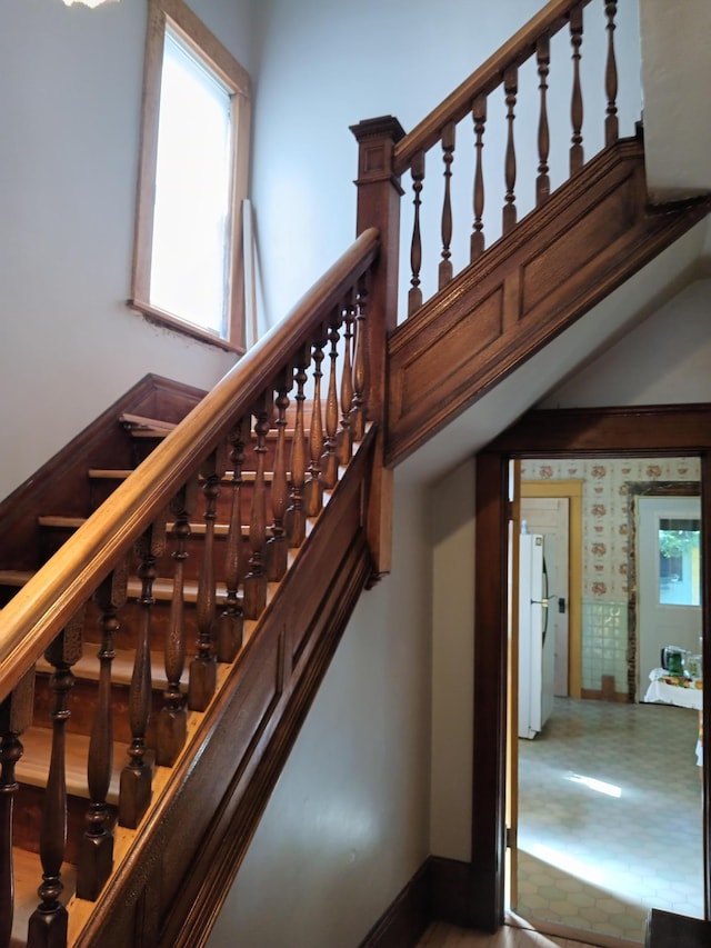 stairway featuring baseboards and plenty of natural light