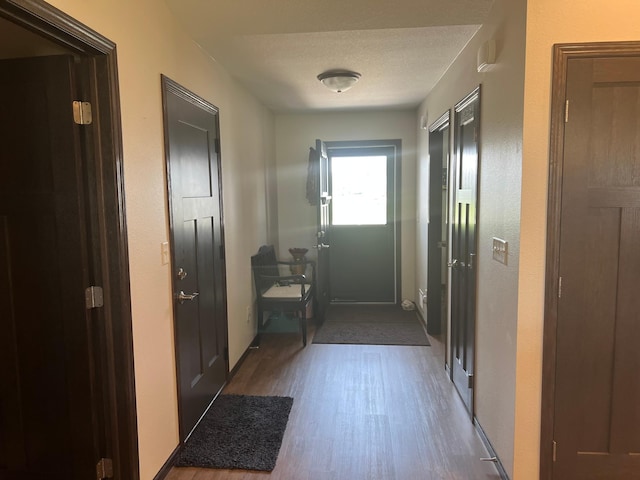 entryway with a textured ceiling and dark hardwood / wood-style flooring