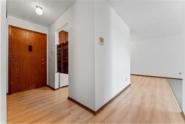 entrance foyer with light hardwood / wood-style floors and a textured ceiling