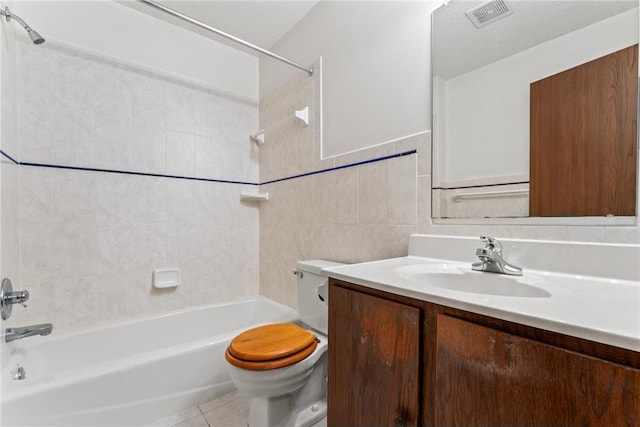 full bathroom featuring toilet, tile walls, tiled shower / bath, vanity, and a textured ceiling