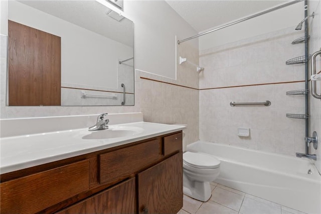 full bathroom featuring vanity, tiled shower / bath, tile walls, tile patterned flooring, and toilet