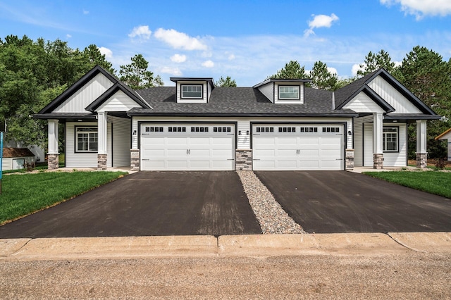 craftsman house with a garage and a front lawn