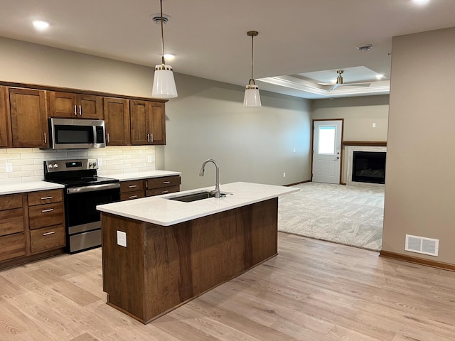 kitchen featuring a center island with sink, light hardwood / wood-style floors, sink, and stainless steel appliances